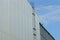 Long iron staircase on a gray metal wall of an industrial building against the sky