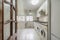 Long kitchen with white cabinets and appliances to match black