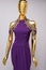 Long, lilac designer, evening, women`s dress handmade on gold, glossy mannequin. With white and gold bead ornament. Isolated on gr