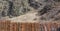 Long line of rural wooden fence made from thin wooden planks protecting private farm in mountains