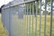 Long metallic gate outside a grassy field