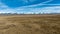 Long narrow gravel road across rural agricultural countryside towards the snow capped Southern alps mountain range