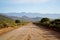 Long open dirt road in mountain landscape