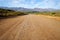 Long open dirt road in mountain landscape