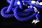 Long open necklace lariat blue color on a dark background