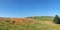 Long panoramic view of green fields and distant village stone houses in rolling west yorkshire dales countryside in colden with