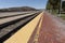 Long parallels merging train tracks and and platform converging into a blurred background