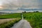 Long path on bavarian field with cloudy sky
