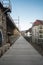 Long paved path beside the arches of a viaduct under a cloudy sky