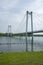 Long pedestrian bridge suspended by ropes across the river.