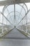 A long pedestrian tunnel with metal arches and mesh design. Aerial pedestrian crossing over the highway, perspective goes to the h