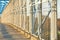 A long pedestrian tunnel with metal mesh design. Aerial pedestrian crossing over the highway, perspective goes to the horizon.