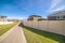 Long pedestrian walkway between walled houses during day