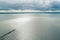 Long pier stretching into calm ocean waters - aerial view.