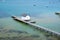 Long pier with white shed in turquoise shallow water.