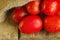 Long plum tomatoes on wooden table. Heap of fresh tomatoes