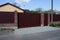 Long private brown red gates and part of a fence