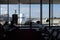 Long range airliner plane waiting in front of an airport seen from the interior of the terminal, from a waiting room
