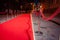 Long red carpet between rope barriers on entrance.