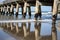 Long repeating pattern and diminishing perspective and shadow of structure underneath Tolaga Bay Wharf, East Coast New Zealand