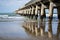 Long repeating pattern and diminishing perspective and shadow of structure underneath Tolaga Bay Wharf, East Coast New Zealand