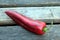 Long ripe red sweet pepper on old wooden grid horizontal photo closeup