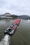 Long river freight boat with red roofing by the Linz castle