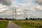 Long row of double high-voltage pylons in a Dutch landscape