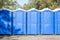 Long row of portable bio toilet cabins. Blue cabines of bio toilets. A large number of street toilets