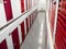 Long row of red color doors of self storage facility. Service to keep safe extra belongings. Nobody. Selective focus. Clean and