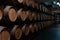 A long row of wooden wine barrels. Modern wine cellar