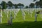 Long rows of white crosses at the Normandy American Cemetery and Memorial, Normandy, France with the sea in the background