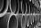 Long series of stacked reinforced concrete pipes in black and white 2