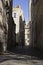 Long shadows cast on alleyway in courtyard.