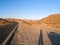 Long shadows of tourist stopped to take in view of Mojave Desert Landforms line highway through desert