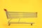 Long shopping cart on yellow background. Sales an discounts concept