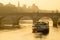 Long shot of a cargo barge passing under the Pont Neuf in Paris during dawn twilight