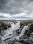 Long shot of cold rushing river in Iceland under gray sky