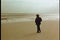 Long shot of man walking on beach