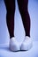 Long slender legs close-up. Thick-soled sneakers. Red stockings or tights. Trend, fashion, trend