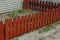 Long small red decorative fence from wooden boards