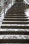 Long snow covered stairs in winter with foot steps and tracks