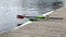 Long sport boat with oars stands at wooden pier at sunny day