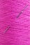 Long stainless needle stuck in purple wool texture thread