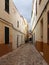 Long straight cobbled picturesque empty narrow street of old houses in cuitadella menorca