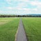 Long straight footpath stratching to the distance in a park