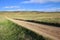 Long straight gravel road in the prairie.