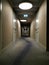 Long straight illuminated hallway from a hotel with mirror perspective