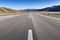 Long straight road on asphalt on mountain plateau