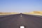 Long straight road through sandy desert Arab Emirates